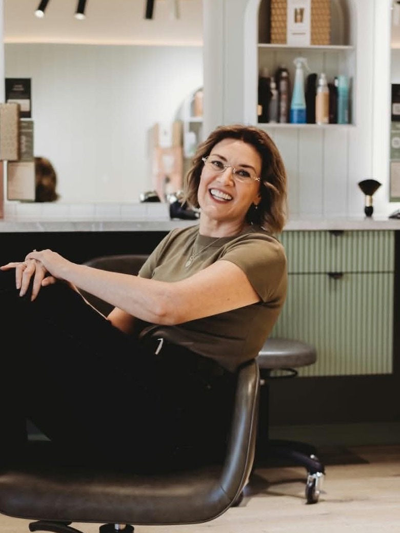 Elle — Master Stylist at Hair Avenue Braddon, seated in a styling chair on the salon floor