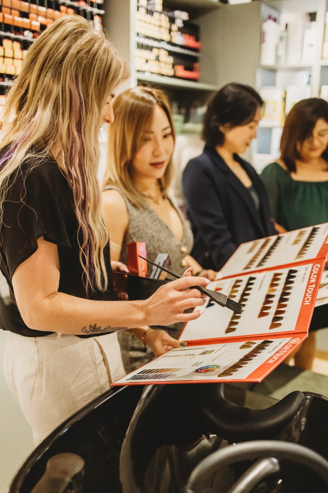 Hair Avenue team reviewing Wella colour swatch charts with a client