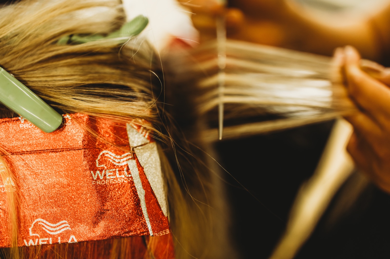 Hand-woven foils being placed through a blonde client's hair with Wella foil paper